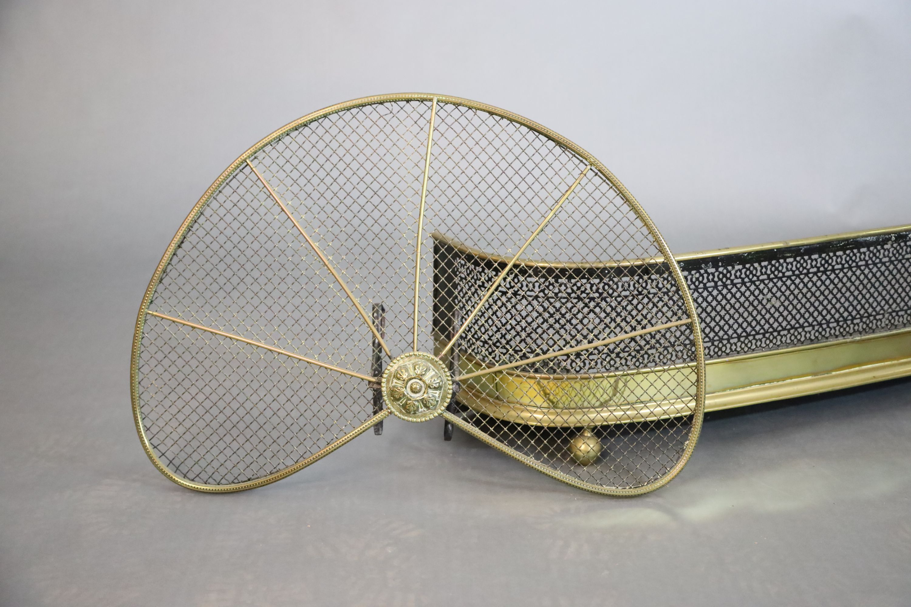 A Regency brass and wire mesh bow fronted kerb and a brass fan shaped spark guard, kerb W.119.5cm D.25.5cm H.27cm guard W.71cm H.46cm